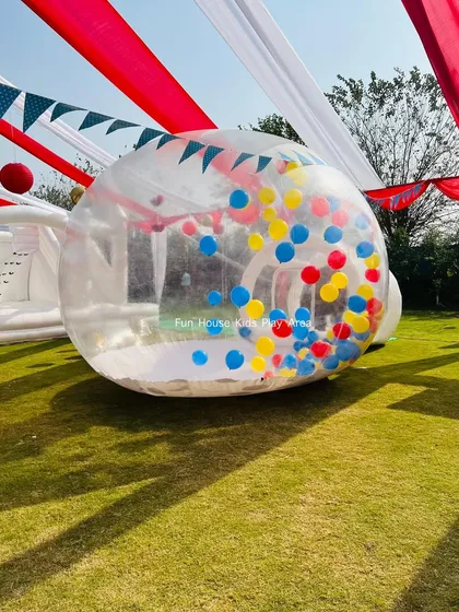 The Bubble House filled with primary-colored balloons, set up under a tent for a circus-themed party. It adds a modern twist to a classic theme.