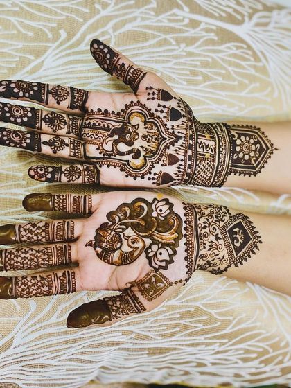 A beautiful design featuring a central Ganesha motif on one hand and a peacock on the other. This is a wonderful way to incorporate spiritual elements into your bridal mehndi.