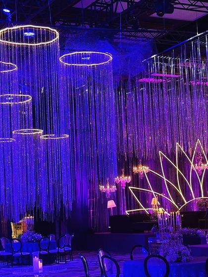 This angle highlights the hanging crystal installations and the neon lotus stage. The deep blue and purple lighting creates a moody and glamorous atmosphere, perfect for a night of music and dancing.