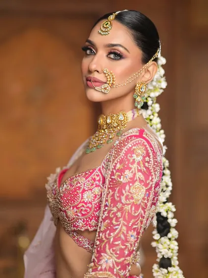 A side profile highlighting the long, flowing braid adorned with fresh gajra. This hairstyle is a timeless choice for a traditional and elegant bridal look.