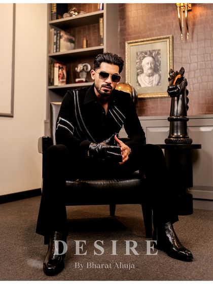 Seated with an air of authority, this image highlights the sleek design and modern details of the black zipper shirt.