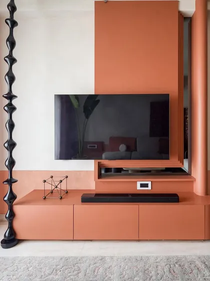 Another view of the TV unit, showing how the modern wooden turnings and terracotta color create a contemporary look while preserving the essence of South Indian style.