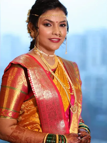 A side profile showcasing the elegant hairstyle and the traditional mundavalya. The makeup is flawless, ensuring she looks perfect from every angle.