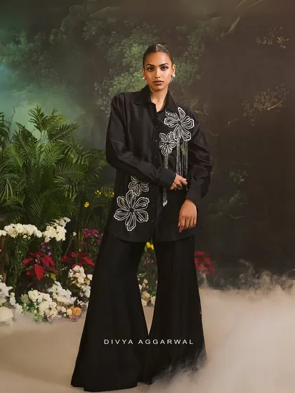 Our Azalea Co-Ord Set, featuring a black shirt with white floral embroidery and tassel details, paired with flared pants.