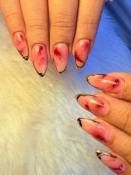 This design combines two major trends: a red marble or "rose quartz" effect and a delicate gold chrome outline. The result is a sophisticated and artistic look that feels both modern and timeless.