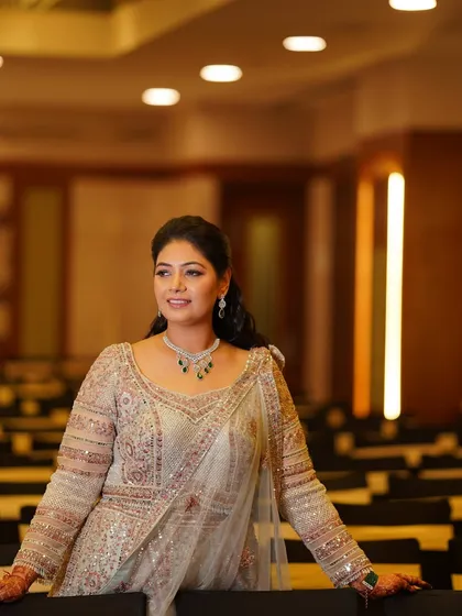 A confident pose in the event space. The bride looks poised and beautiful, her makeup perfectly complementing her elegant attire and the sophisticated ambiance.