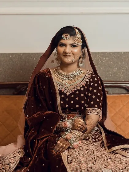 A stunning solo portrait of a Muslim bride in her rich, velvet lehenga, looking elegant and poised.