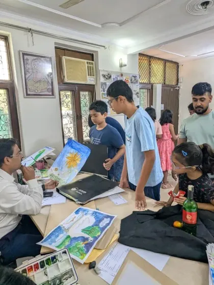 A portfolio review session in progress. Our instructor discusses the student's work with them and their parents, providing constructive feedback.