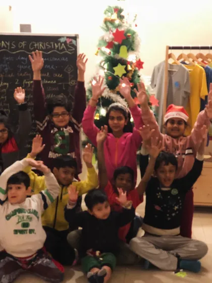A happy group of children waving in front of a Christmas tree. Our holiday retreats are all about celebrating togetherness and joy.