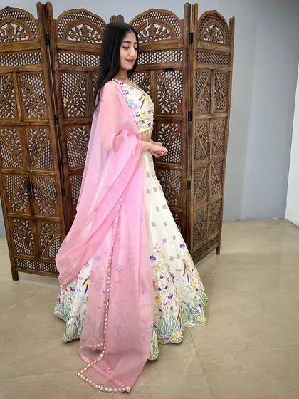 The pearl-lined pink dupatta adds a delicate and elegant touch to this playful lehenga.