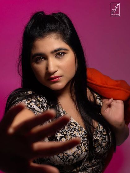 A creative shot using a hand in the foreground to create depth and draw the viewer's eye. The dramatic lighting adds to the mood.