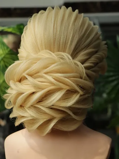 Another angle of the beautiful reception bun, showcasing its full shape and intricate texture. This is a true statement hairstyle for a grand occasion.