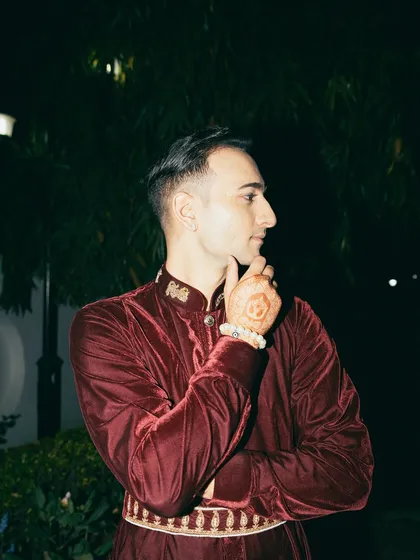 A thoughtful pose, highlighting the henna and the detailed embroidery on the collar.