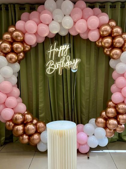 A beautiful balloon arch and neon "Happy Birthday" sign, ready to welcome the guests of honor.