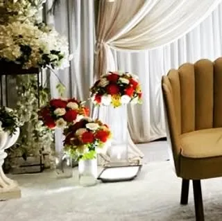 Small floral arrangements in glass vases, used as accent pieces on the stage. These details help to fill the space and carry the floral theme throughout the entire setup.
