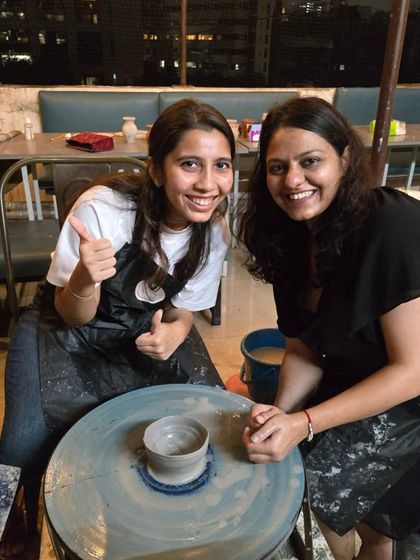 Success. A happy guest gives a thumbs-up next to her freshly made bowl on the wheel. We love celebrating these small victories with you.