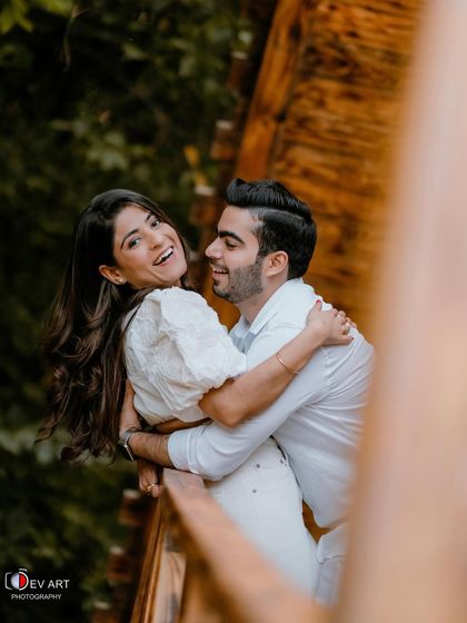 A playful and happy moment captured in a rustic setting. The makeup is light and enhances her natural beauty and joyful expression.