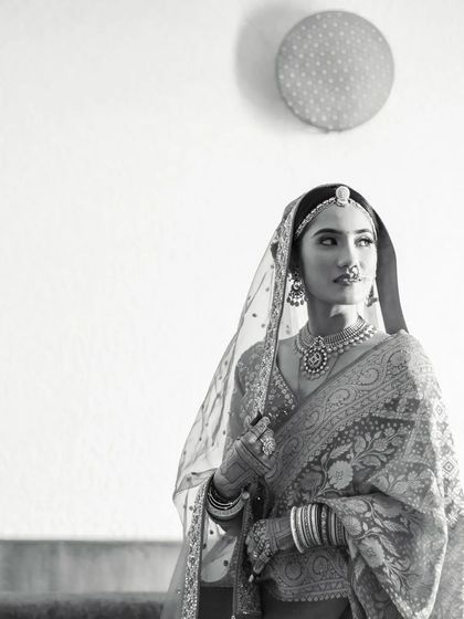 A minimalist black and white bridal portrait, using negative space to draw all attention to her elegant form and traditional attire.
