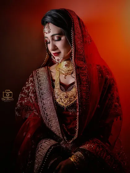 A dramatic portrait of bride Afsana, with a warm red light creating a powerful and cinematic feel. This showcases our creative use of lighting.