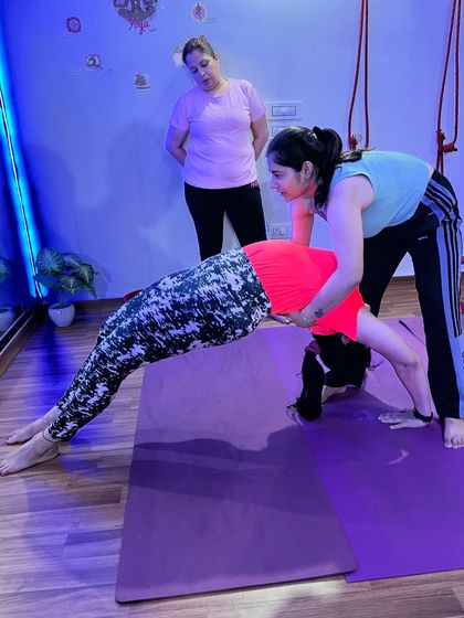 Assisting a student to safely come out of a wheel pose.
