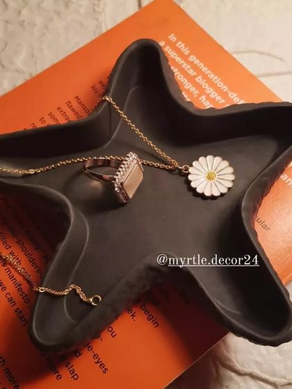 Another view of our black starfish tray, styled on a book to show its clean lines and matte finish.