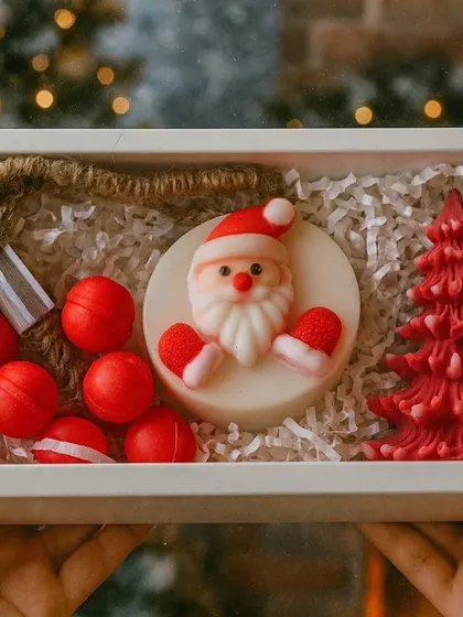 This Christmas gift box captures the magic of the season. It features a detailed Santa soap, a festive tree-shaped soy wax candle, and playful grape-shaped hanging soaps, all ready to be gifted.