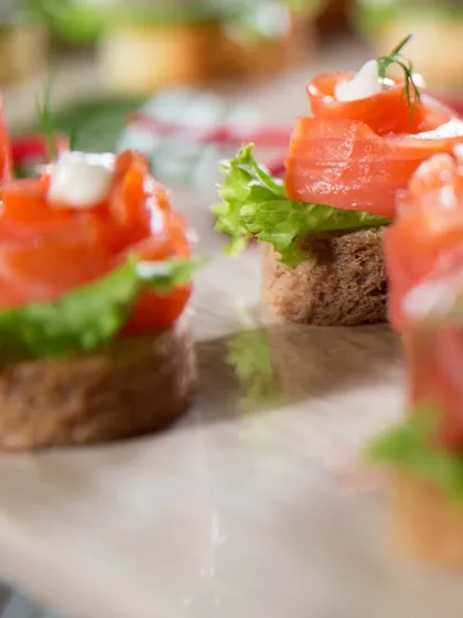 A close-up of my Smoked Salmon Canapés. Delicate smoked salmon is artfully arranged on a bed of lettuce over rye bread, offering a classic and sophisticated flavour.