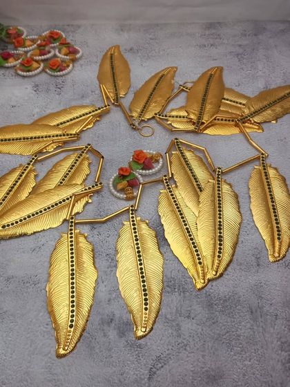 A collection of new arrivals, including a golden leaf door toran and small floral haldi-kumkum holders.