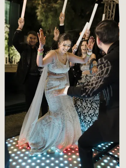 The bride owns the dance floor, her joy infectious as she dances with her groom during the Sangeet.