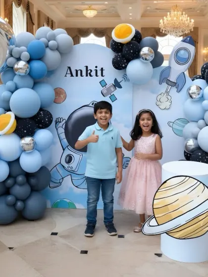 Two happy partygoers enjoying the space-themed photo booth I designed for Ankit's birthday. It's always a joy to see kids interacting with the magical worlds I build.