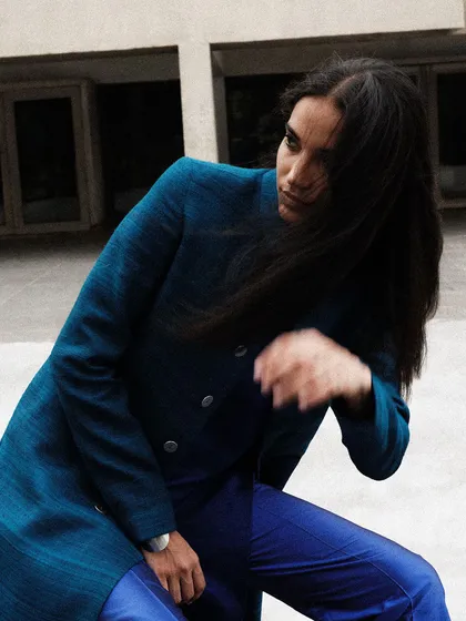 A candid, windswept moment that brings a sense of life and movement to the otherwise static and severe architectural setting.