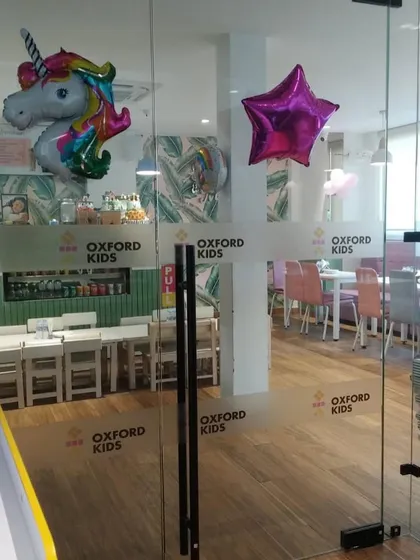 The glass entrance to our cafe, decorated with unicorn and star balloons for a party.