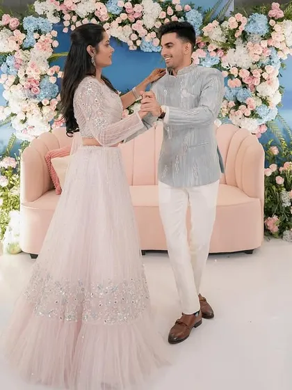 Yash and Sakshi share a dance at their engagement party. The backdrop of blue and pink florals against a sky-blue wall created a dreamy, pastel-perfect setting.