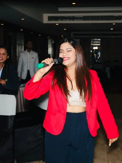 A joyful shot of me singing and interacting with the audience at their tables during the Skills Bazzar event.