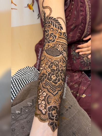 A close up on the forearm, where you can see the interplay of bold flowers and fine lines.