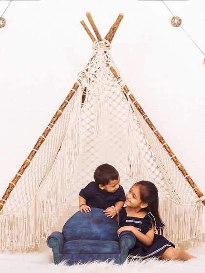Capturing the playful dynamic between siblings is always a joy. This shot shows a sweet moment of conversation between brother and sister in a cozy, decorated teepee.