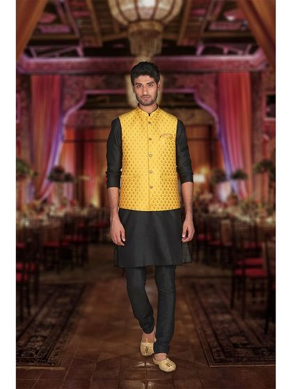 Elevate your traditional look with this stylish kurta-jacket set. A black kurta paired with a bright yellow brocade jacket is a bold and festive choice for any celebration.