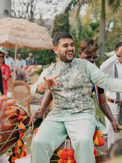 The groom enjoying a ride on the dhol, a classic baraat moment full of energy and fun.