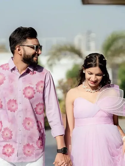 A candid walking shot of a couple. The lavender gown flows beautifully, and the partner's coordinated shirt creates a picture-perfect look.