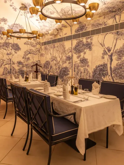Our indoor dining area is set for an evening of refined taste. The elegant blue and white decor, inspired by Mediterranean aesthetics, provides a sophisticated backdrop for your meal.