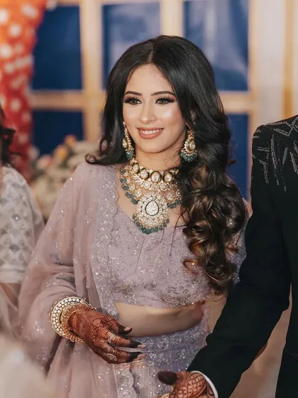 A candid moment of the happy reception bride. Her makeup is soft and glowing, ensuring she looks just as beautiful in candid shots as she does in posed portraits.