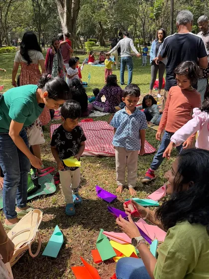 Children engaged in a paper craft activity, making colorful boats. Our workshops often include a creative segment related to the story, allowing kids to make their own take-home treasures.