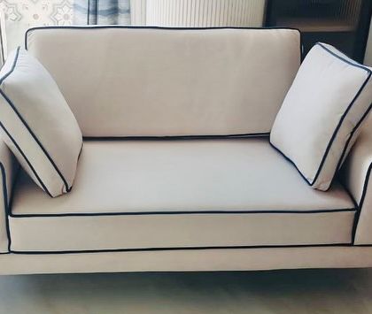 Our Linear Sofa adds just the right dimension to your home. This two-seater version features clean lines, contrasting black piping, and unique metal handle details on the arms for a sharp, contemporary look.