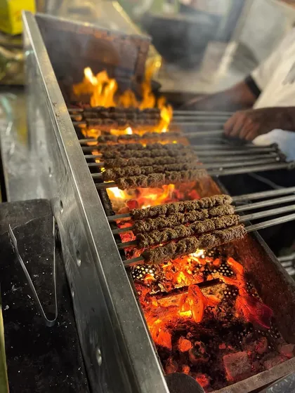 The intense heat of the charcoal grill is visible as it cooks the Mutton Seekh Kebabs, a testament to my authentic grilling methods.
