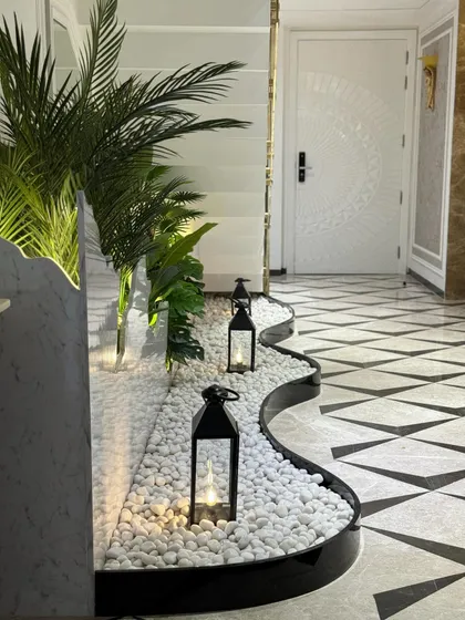 Another view of the under-staircase garden, showing how it elegantly follows the curve of the wall. The lanterns add a warm, inviting glow to the cool tones of the pebbles and plants.