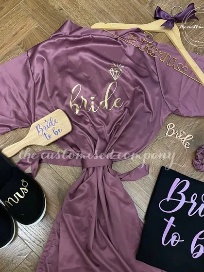 Elegance in every detail for the bride's journey down the aisle. This set features a personalized satin robe, matching slippers, a custom "Bride to be" t-shirt, and other essentials.
