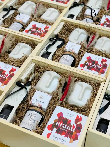 Customizing gift hampers is my specialty. These wooden boxes, filled with unique items like face-shaped candles and Araku coffee, were curated to a specific artistic theme for a client.