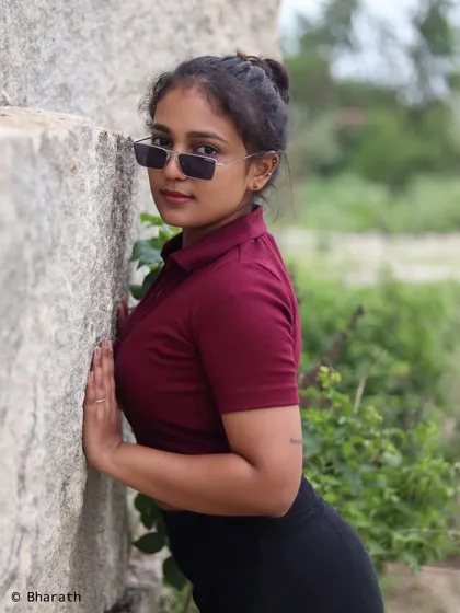 A full-body shot of the model leaning against the rock, showcasing the entire casual outfit.