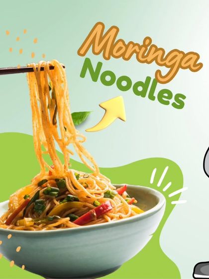 A delicious bowl of our Moringa Noodles, held by our mascot. These noodles are steamed, not fried, and packed with the power of moringa leaves for a truly healthy meal.