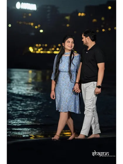A nighttime stroll along the water's edge. The reflection of the city lights on the Ganga adds a magical sparkle to this romantic pre-wedding photo.